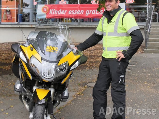 Stauberater Joachim Paul steht neben dem ADAC Motorrad.